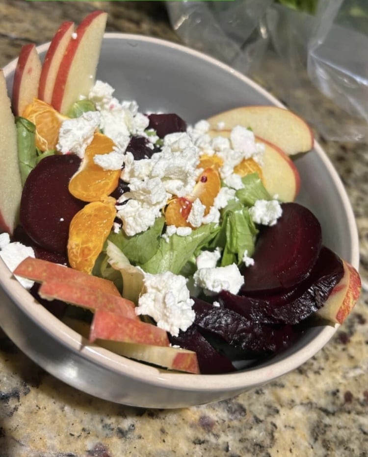 salad with sliced apples, sliced oranges, feta cheese, a little bit of green lettuce, and sliced, roasted beets