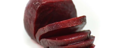 cooked round deep red beet with 4 slices leaning off
