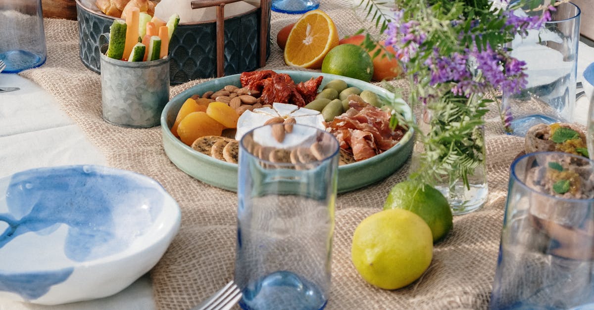 A beautifully set brunch table outdoors featuring fresh fruits, vegetables, and flowers.